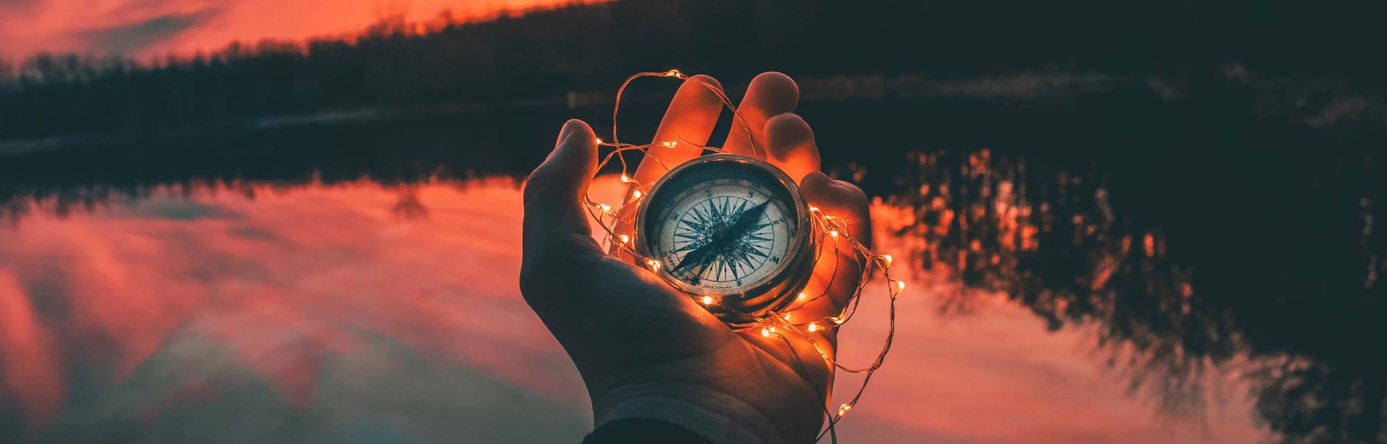 banner photo of a hand holding a compass